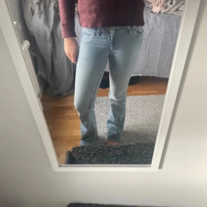 Ljusblå bootcut jeans från Nelly - Ljusblå jeans från Nelly med bootcut passform och klassisk femficksdesign. Snygga rosa sömmar på bakfickorna ger en unik touch. Jeansen har låg midja och är tillverkade i mjukt denimtyg med lätt tvättad look. Uppsydda så de passar mig som är 165, går dock att sprätta ner till original längd utan svårigheter. Storlek 32, knappt använda 