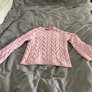 Rosa kabelstickad tröja Gina Tricot XS - Supersöt ljusrosa kabelstickad tröja från Gina Tricot i storlek XS. Tröjan har rund halsringning, långa ärmar och ett chunky stickat mönster som ger en mysig vibe. Perfekt att styla med jeans eller kjol för en trendig look. Slutsåld på hemsidan 