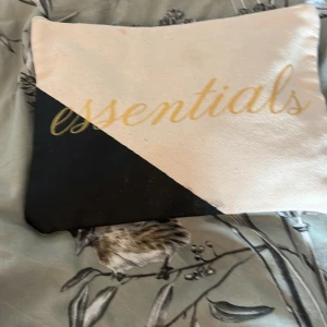 Beige och svart necessär med text -  Säljer en Mystery bag med 10 produkter från dusch grejer till smycken med värde av 129kr säljer för 89kr 