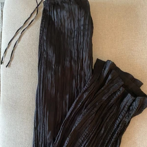 Glansiga byxor  - Svarta byxor i glansigt material från H&M.