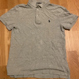 Grå pikétröja Polo Ralph Lauren - Hej säljer nu min grå Ralph Lauren piké för att den har blivit för liten. Den är storlek L barn. Den är i grå bomull och har ett broderat märke vid bröstet. Ny pris är ca 1100 så jag säljer den för 350 för det känns rimligt men kan diskutera pris. Den är perfekt för en clean och stilren look.