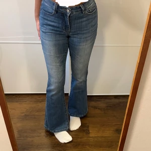 Blå bootcut jeans från Madlady - Snygga blå bootcut jeans från Madlady i storlek EU32/Short. Jeansen har klassisk femficksdesign, normalhög midja och är tillverkade i en mix av bomull, polyester och elastan för en bekväm passform. Perfekta för dig som gillar en retroinspirerad look.