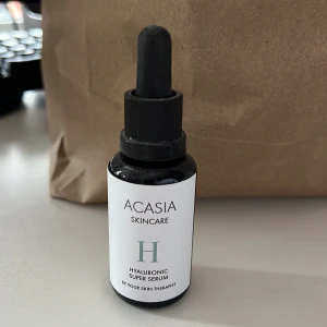 Acasia Hyaluronic Super Serum 30ml - Acasia Hyaluronic Super Serum är ett ansiktsserum med hyaluronsyra, niacinamid, vitamin C och E. Kommer i en svart glasflaska med pipett och vit etikett. Perfekt för dig som vill ha extra fukt och glow i din hudvårdsrutin. Nypris 399kr. Helt oanvänd.