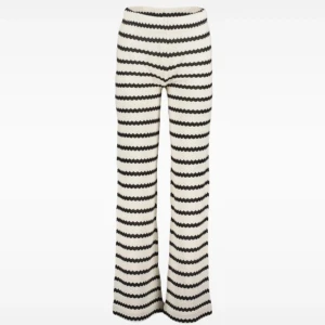 Randiga stickade byxor i svartvitt - Snygga stickade byxor med svartvitt vågigt randigt mönster. Byxorna har en rak och lite vidare passform med hög midja. Perfekta för dig som vill sticka ut med en cool och trendig look.