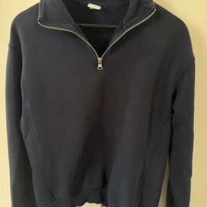 Svart half zip tröja från Zara - Svart långärmad tröja från Zara med half zip framtill och hög krage. Tröjan är i mjuk bomull och har en clean, enkel look utan mönster eller detaljer. Perfekt för chill dagar och passar till allt. Snygg och stilren modell.