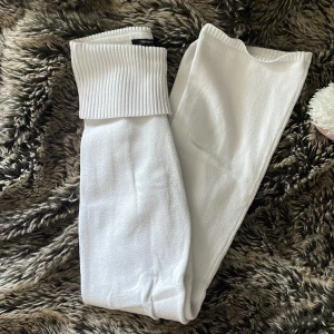 Vita stickade byxor yogapants - Supermysiga vita stickade yoga pants från Forever 21 i storlek S. De har en bred ribbad midja som kan vikas ner och raka ben med lätt utsvängning. Perfekta för chill dagar hemma eller när du vill vara extra comfy. Materialet är mjukt och stretchigt stickat tyg.