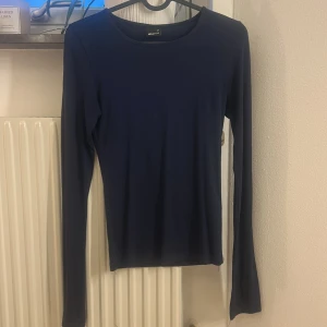 Mörkblå långärmad topp - En stilren mörkblå långärmad topp från Gina Tricot med rund halsringning. Toppen är tight men väldigt skönt material 