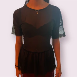 Svart transparent peplumtopp - Snygg svart peplumblus från Only! Toppen är i transparent material och är i storlek L 