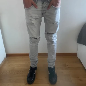 Dondup Jeans - Säljer ett par stiliga snygga Dondup jeans i storleken 29/32, och modellen är 174 och väger cirka 55-60kg. jeansen är i bra skick men några och en sydda hål. Kom gärna med prisförslag eller funderingar!