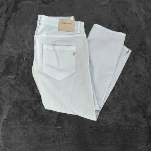 Vita byxor från Dondup - Snygga ljusvita byxor från Dondup med klassisk femficksdesign och diskret logga på bakfickan. Byxorna har raka ben och är tillverkade i ett mjukt bomullsmaterial som känns skönt mot huden. Perfekta för dig som gillar stilrena och fräscha vibes. Lite fläckig 