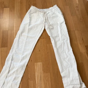 Vita linnebyxor från Roxy XS - Snygga vita linnebyxor från Roxy i storlek XS. Byxorna har elastisk midja med snörning och två fickor fram. Perfekta för chill dagar och har en avslappnad passform med raka ben. Lätta och luftiga i linne för en fräsch look. Som nya, säljer pga för små
