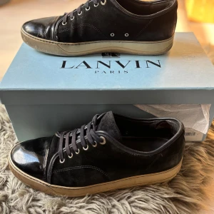 Lanvins - Snygga marinblåa sneakers från Lanvin med ovandel i mocka och detaljer i blankt skinn på tån. De är i storlek 43. Finns slitningar så som vid hälen inuti (se sista bilden) men annars i bra skick. Ger ett fint intryck. Skick är 7/10. Box medföljer! Pris går att diskutera, hör av dig om du har frågor! 