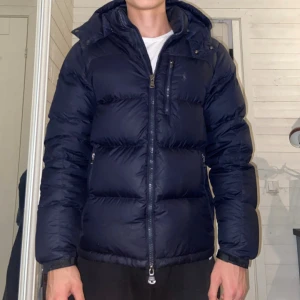 Ralph Lauren puffer jacket - Mycket fint skick utan stora defekter, storlekstagen är tyvärr borta men annars inga fel. På bilderna kan den uppfattas som marinblå men den är alltså svart.  Storlek S/M, passar perfekt på mig som är 182 cm. Kom gärna med prisförslag eller andra frågor!