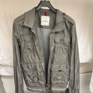 Moncler field jacka  - Säljer nu en riktigt fet moncler field jacka? I sjukt bra skick bestämmer själv skick utefter bilder men tycker de är väldigt bra, storlek 4 passar     S/M, perfekta hösta jackan nu som inte är för varm eller för kall så perfekt till höst/vår. Passar till det mesta självklart äkta🤩, skriv vid minsta fundering🌟