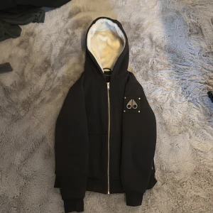 MOOSE KNUCKLES HODDIE - Väldigt stilren och skön hoddie nu till hösten. Jag använde den även som jacka och det funkade perfekt. Väldigt skön äkta päls inuti jackan. Väldigt snygg och bra skick. Storlek XL i barnstorlekar skulle säga att den passar om du är från 150-173, passar också om du skulle ha storlek Xs.
