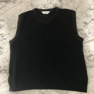 Svart stickad väst från H&M - Svart stickad väst från H&M med v-ringad hals. Västen har en loose passform och passar perfekt till en T-shirt eller skjorta. Den är sjukt skön och bekväm. Västen är i storlek 146/152 men passar upp till storlek 170.