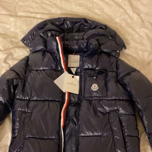 Mörkblå Moncler pufferjacka med huva - Säljer nu en mörkblå pufferjacka från Moncler väldigt fräsch och varm till vintern eller hösten storlek S/2 men passar också M. 