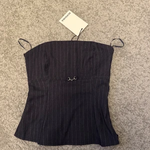 Randig bandeautopp från Bershka - Säljer en mörkblå bandeautopp från Bershka. Aldrig använd, säljer för att den var förliten. Är en storlek S men väldigt liten i storleken! Nypris är 259kr säljer för 200kr
