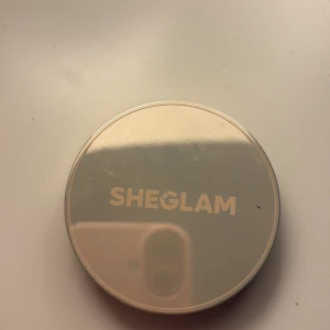 SHEGLAM Silk Haze Cream Bronzer Umber - SHEGLAM Silk Haze Cream Bronzer i färgen Umber. En krämig bronzer i en rund, spegelblank burk med lock. Färgen är en djup brun nyans som passar perfekt för att skapa värme och kontur i ansiktet. Innehåller 8,6 g produkt.