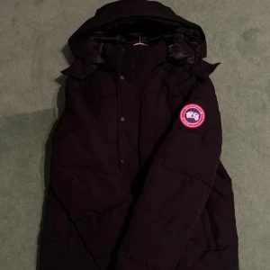 Svart dunjacka från Canada Goose - Säljer en svart dunjacka från Canada Goose med klassisk logga på ärmen. Skriv vid frågor! Kom med prisförslag! :). MÖTS I STOCKHOLM!
