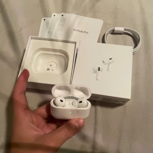 AirPods Pro (2nd generation) - Apple AirPods Pro (2nd generation) i mycket fint skick, komplett med originalkartong, laddningskabel och manualer. Trådlösa hörlurar med aktiv brusreducering och MagSafe-kompatibelt laddningsetui. Inga synliga defekter eller slitage, ser ut som nya.