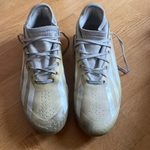 Adidas fotbollsskor i beige och vitt - Säljer ett par Adidas fotbollsskor i beige och vitt . Crazyfast original pris 1349