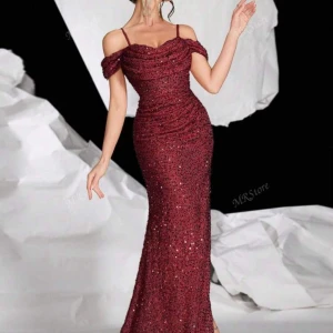 Vinröd glittrig långklänning - Supersnygg vinröd långklänning med glittriga paljetter och offshoulder-detalj. Klänningen har smala axelband och en figurnära passform som framhäver siluetten. Perfekt för dig som vill sticka ut på bal eller fest! Pris kan diskuteras 