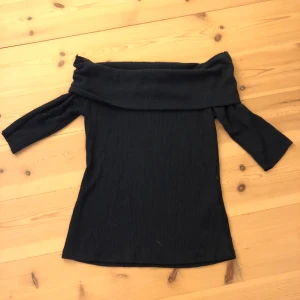 Svart offshoulder topp Gina Tricot - Svart ribbad offshoulder topp från Gina Tricot Perfekt för dig som gillar stilrena och trendiga plagg med en snygg siluett. Tröjan är offshoulder och jag har klippt av ärmarna.