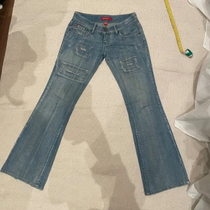 Lågmidjade jeans - Utsvängda ljusa Lågmidjade jeans med coola detaljer och slitningar! Har tyvärr blivit för små för mig🥹 Miss Sixty storlek: 26 Innerbenslängd: 76cm midjemått: 35cm