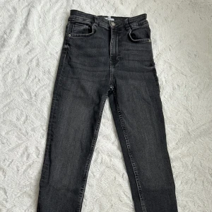 Svarta skinny jeans från Zara, stl 34 - Snygga svarta skinny jeans från Zara i storlek 34. Hög midja, klassisk femficksmodell och dragkedja med knapp. Jeansen har en mörk tvätt och smal passform som sitter tight hela vägen ner. Använd få gånger, skriv om flera bilder önskas 🥰