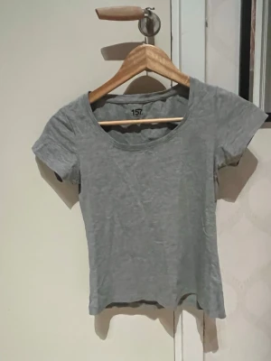 Svart topp med spets från 157, S - Svart kortärmad topp från 157 i storlek S. Rund halsringning och ärmslut med fina spetsdetaljer som ger en extra touch. Toppens passform är normal och materialet känns mjukt och bekvämt. Perfekt för dig som gillar stilrena och enkla plagg med lite edge.