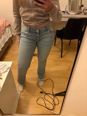 Ljusblå jeans straight fit - Säljer ett par klassiska jeans i ljusblå tvätt. Modellen har hög midja, raka ben och fem fickor. Jeansen är tillverkade i robust denim och har silverfärgade knappar. Perfekt passform för dig som gillar en tidlös och chill look. Köpta med defekt se sista bild. Aldrig använda annars. 