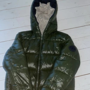 Grön pufferjacka från Save The Duck - Säljer denna riktigt feta Save The Duck jackan i grön med vit insida. Skick 9/10 har använts ett fåtal gånger. Storlek L. Kvitto finns