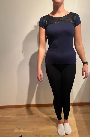 NY: Marinblå t-shirt med svarta paljetter, Esprit. Med lappar - Tvättråd: 30°  Nypris: 199 kr 