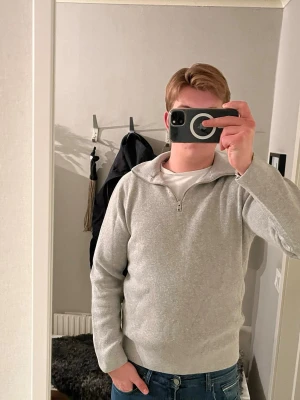 Grå half zip tröja i bomull - Snygg grå tröja med half zip och krage, perfekt för dig som gillar enkel och stilren look. Tröjan har lång ärm och är gjord i mjuk bomull som känns skön mot huden. Passar till jeans och funkar året runt. Fräsch och klassisk design.