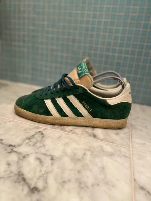 Adidas Gazelle gröna  - Tjena! Säljer ett par gröna adidas gazelle i storlek 42,5 är hyfsat bra kvalité kanske använda 20-25 ggr bilden är med skoblock om ni vill ha utan eller har flera frågor är det bara att skriva! 