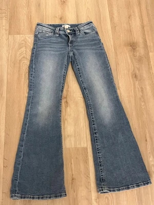 Blå bootcut jeans från Gina Tricot - Snygga blå bootcut jeans från Gina Tricot i storlek 158. Jeansen har markerade sömmar och coola detaljer på bakfickorna. Jeansen ä använda och tvättade en gång. Tyvärr har några av stenarna på bakfickorna rasat av. Pris kan diskuteras 