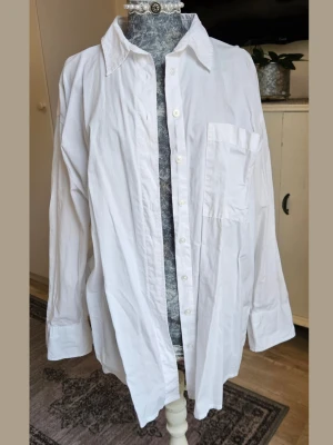 Vit oversized skjorta med ficka - Klassisk vit skjorta i oversized modell med lång ärm och bröstficka. 