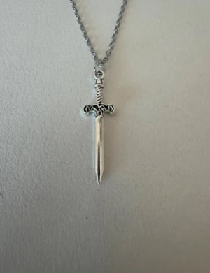 Silverhalsband mindre svärd - Perfekta julklappen 🌲  Säljer smycken som skapats som hobby av mig och dottern.   Halskedjor är 50cm.  Bilder på berlock kan vara missvisande så är det viktigt så fråga gärna om mått 🌹  Smycken är inte av äkta guld/silver .   Inga bud godtas då priserna är så billiga❤️
