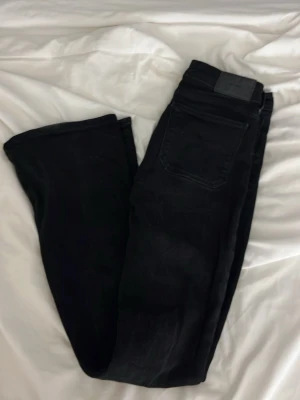 Svarta jeans med bootcut - Säljer ett par svarta jeans med bootcut-modell. De är nersydda till Lågmidjade