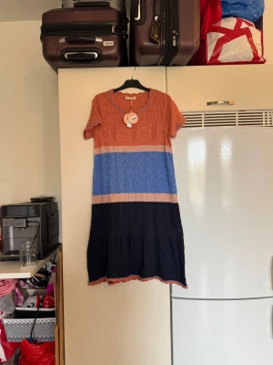 Odd Molly Angelica långklänning flerfärgad - Superfin klänning från Odd Molly i modellen Angelica Dress. Klänningen har virkade detaljer och breda blockränder i rost, blått, beige och mörkblått. Kortärmad med rund halsringning och vågig kant nertill. Perfekt för dig som gillar färg och mönster! Från märket Odd Molly. Storlek 3 som enligt deras storleksguide motsvarar en L. Helt ny med tags/ prislapp fortfarande kvar. 
