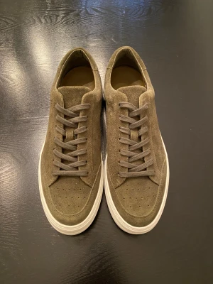 J Lindeberg mocka sneakers gröna oanvända - Säljer ett par gröna J Lindeberg mocka sneakers som aldrig använts. Jag beställde dom men kom i fel storlek och kunde inte lämna tillbaks dom. Går för 1300 nya och är storlek 44