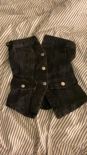 Svart denim topp från Zara - Säljer en svart jeans topp från Zara. Toppen är axelbandslös och har en tight passform som framhäver midjan. Perfekt för fester eller finare tillfällen!❤️