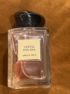 Armani Prive Santal Dan Sha parfym - Lyxig parfym från Armani Prive med modern design och exklusiv känsla. Perfekt för dig som vill sticka ut med en unik och elegant doftaccessoar. Santal Dan Sha ger en sofistikerad vibe till din stil.