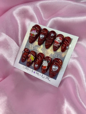 XmasSan (M);Medium Almond - Säljer ett set med handgjorda press-on naglar i glittrigt röd färg med spetsig form. Naglarna har 3D dekorationer som Hello Kitty i tomtedräkt, hjärtan, nalle och julklapp, samt vita detaljer. Perfekt för dig som vill ha extra cute och festliga naglar.M: 16 mm, 12 mm, 12,5 mm, 11,5 mm, 10 mm