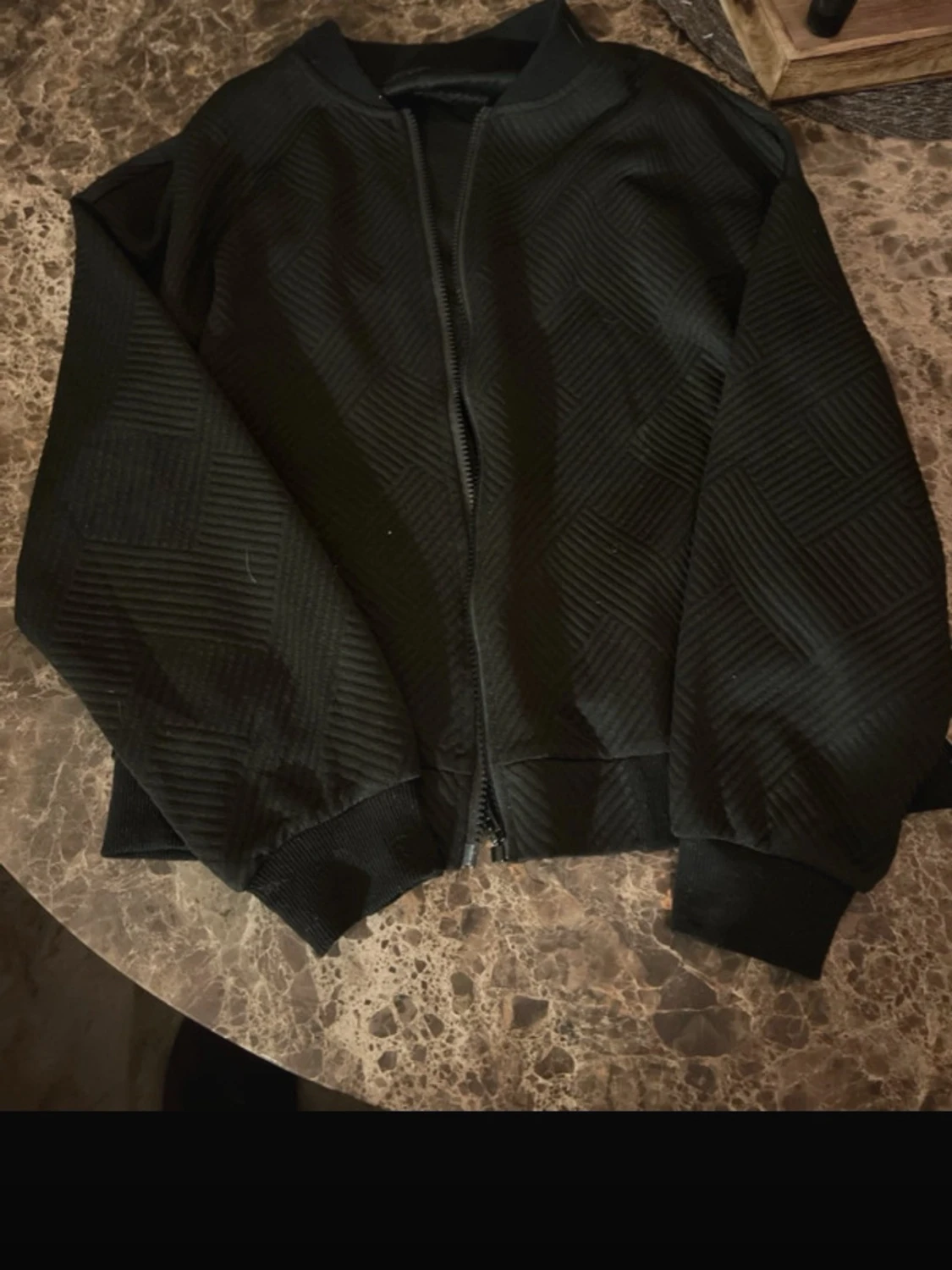 Svart bomberjacka med strukturmönster