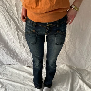 Lee Jeans (återförsäljning!!!) - Lågmidjade vintagejeans från Lee 💙 Mindre slitningar förekommer på innerbenet och etiketten på baksidan. Innerbenslängd 81 cm Midjemått 33 cm! Köpte för ungefär 1-2 år sen, använda men inte synligt!🥰 Obs. Uppsprättade nere vid benen för längre ben, är 173cm och är okej längd för mig😊