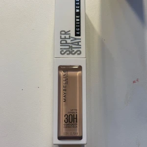 Maybelline Super Stay Concealer 10 - Maybelline Super Stay Active Wear Concealer i nyansen 10. Ger upp till 30 timmars täckning och kommer i en smidig tub på 10 ml. Perfekt för att täcka mörka ringar och ojämnheter. Ljus beige färg, lätt att applicera med applikator.
