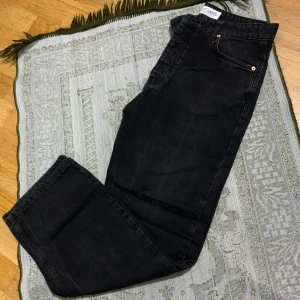 Svarta jeans från Just Junkies - Svarta jeans från Just Junkies i 100% bomull. Klassisk femficksmodell med raka ben och normal passform. Snygga detaljer med metallknappar och läderpatch bak i midjan. Perfekta till sneakers eller boots.