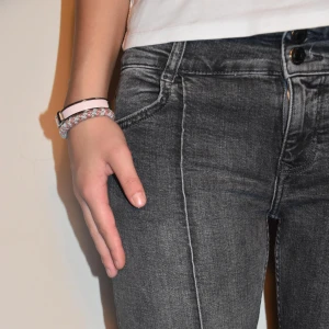 Mörkgrå bootcut jeans med låg midja  - Snygga mörkgrå bootcut jeans med låg midja och dubbla knappar framtill från bershka. Midje längd 36cm och passar någon som är ca 164-172cm. Längd 34